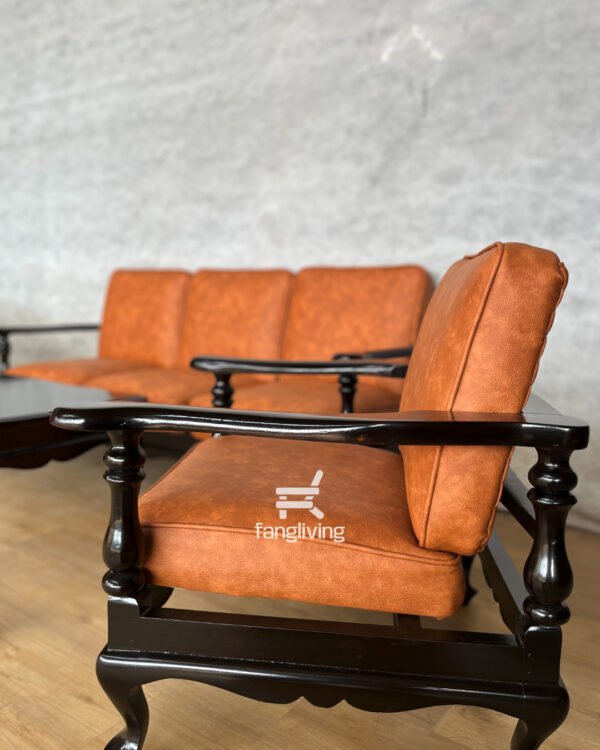 Tampilan dekat sandaran tangan kursi tamu jati dengan finishing hitam mengkilap dan detail ukiran halus